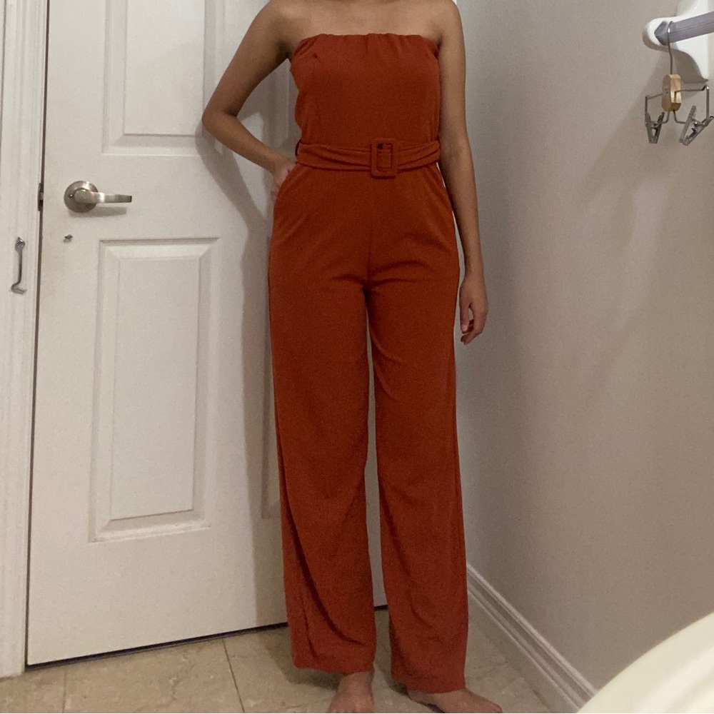 Stylish burnt orange strapless jumpsuit with belt attached to cinch waist